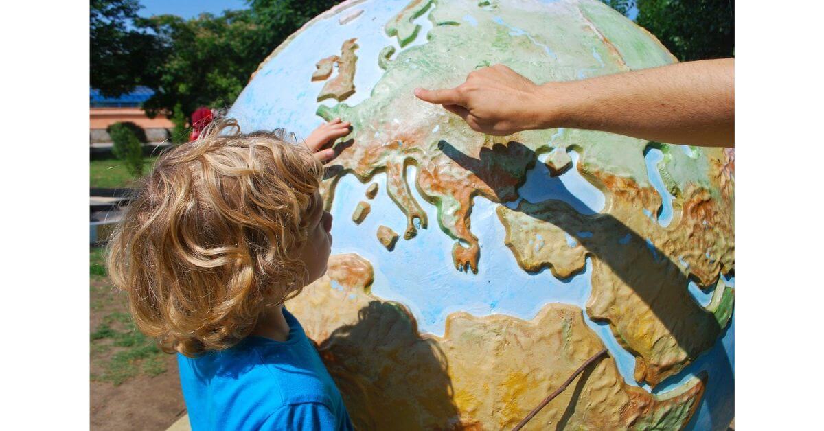 a good teacher trying to teach world map creatively in a big globe