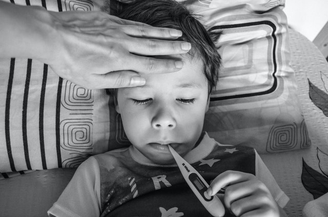 Sick kid using thermometer
